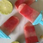 Watermelon Popsicles on granite with limes
