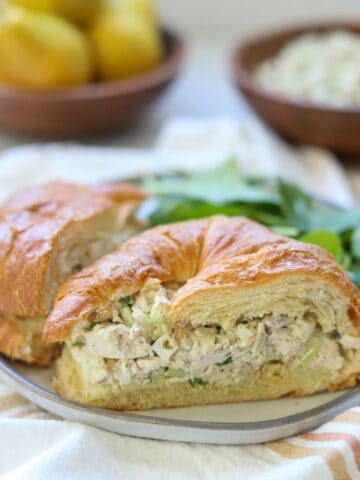 chicken salad croissant cut in half on a plate