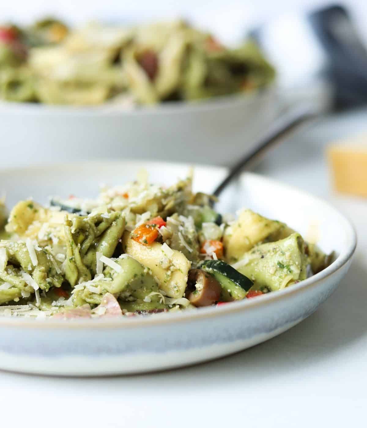 gray plate with serving of tortellini pesto pasta salad