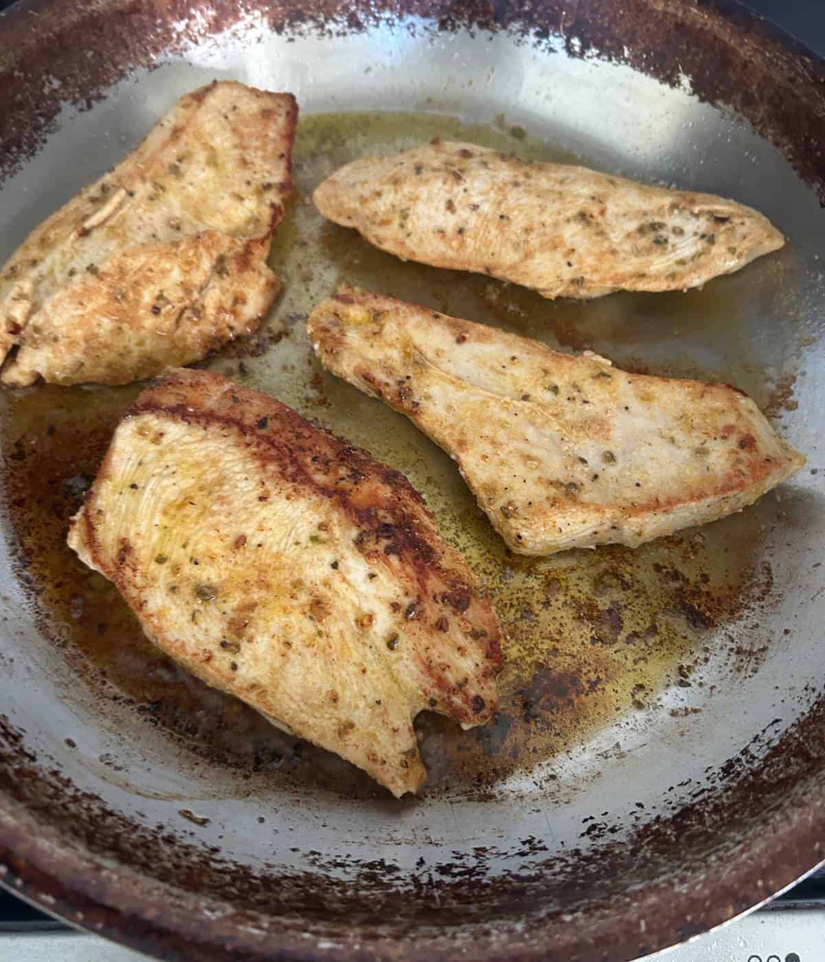 Chicken sautéing in pan.