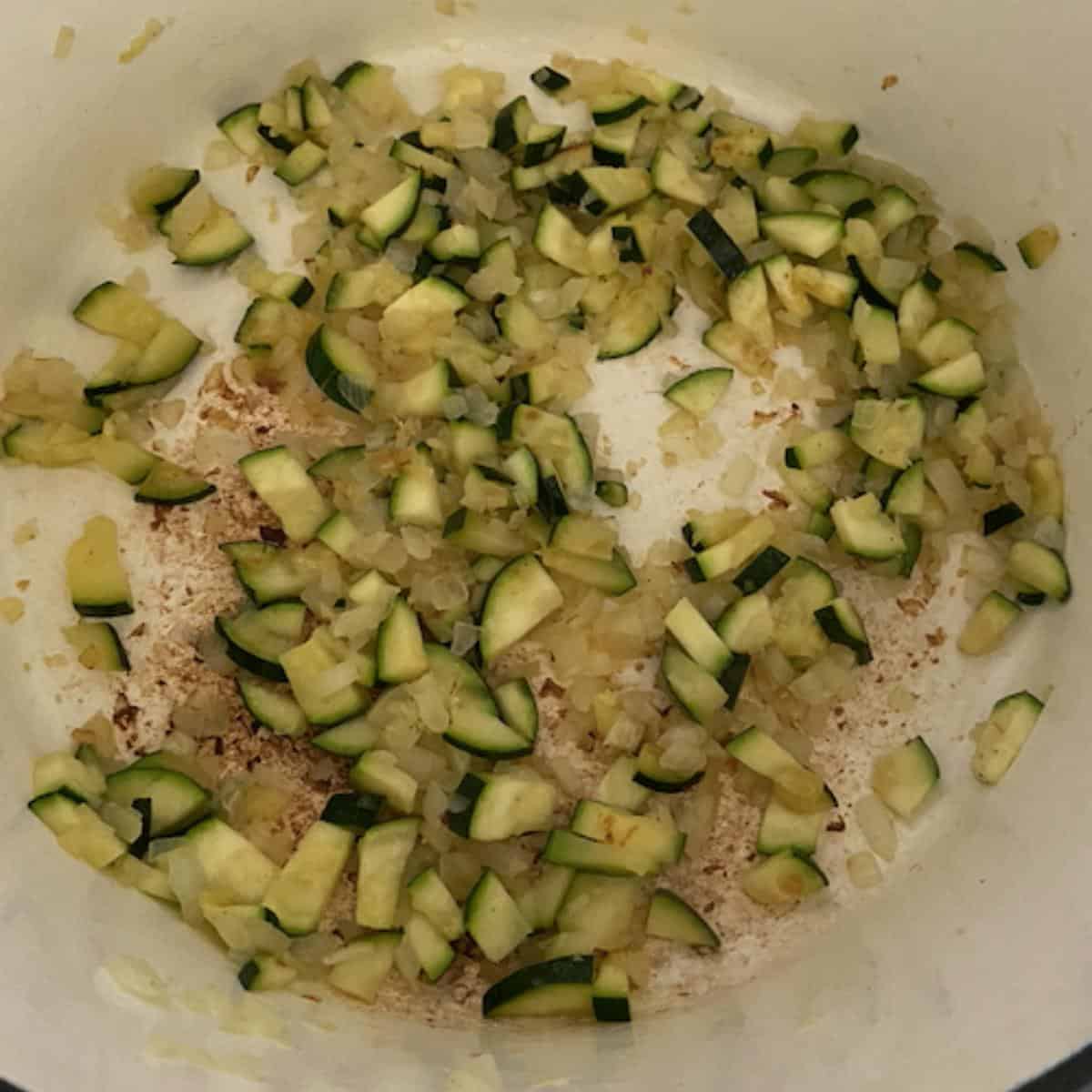 zucchini and onions cooking in dutch oven
