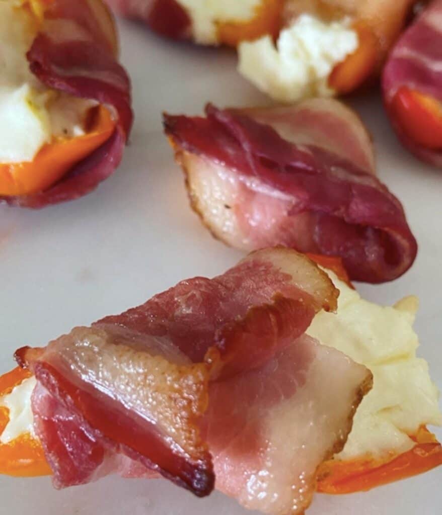 close up of cream cheese stuffed sweet pepper wrapped in bacon