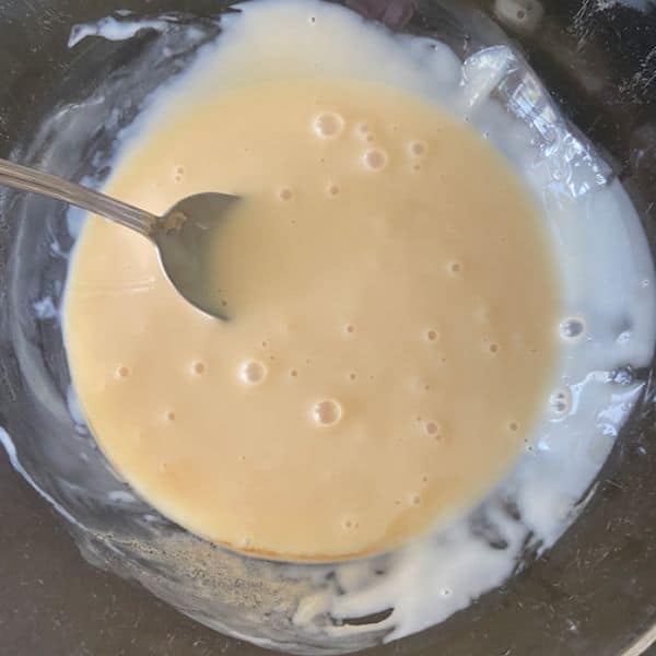 sweetened condensed milk mixture in glass bowl with spoon
