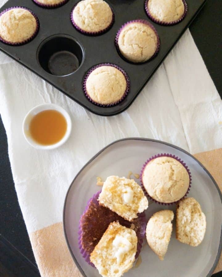 corn muffins on a plate with honey on the side