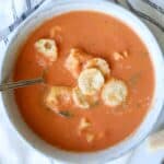 creamy tortellini soup in gray bowl with vintage spoon