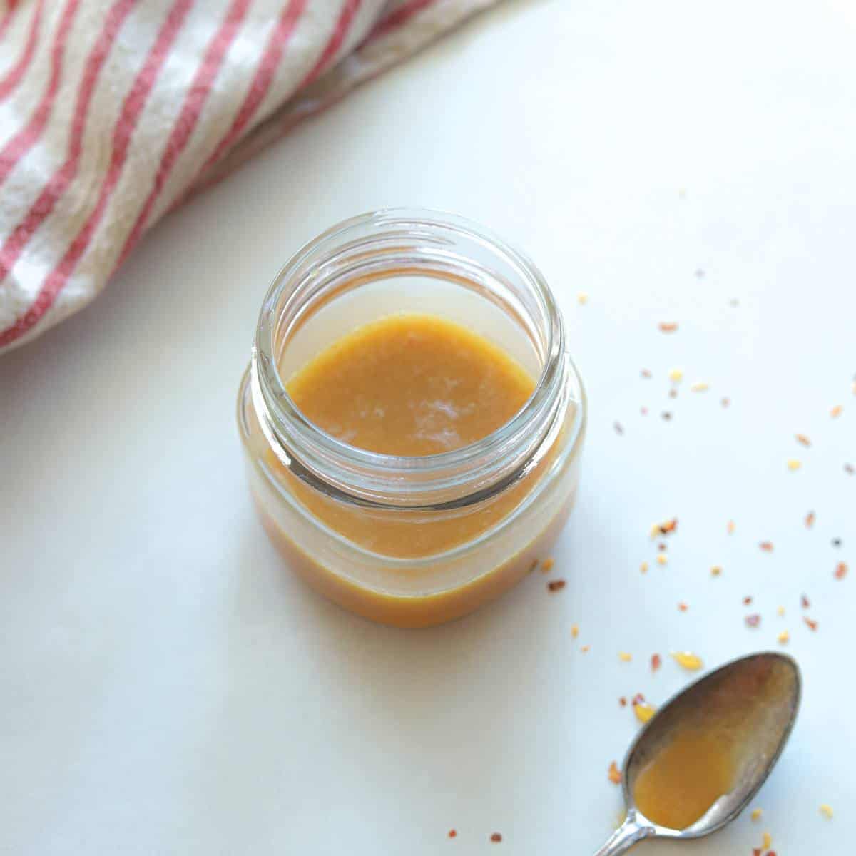 jar full of spicy honey mustard with spoon on the side