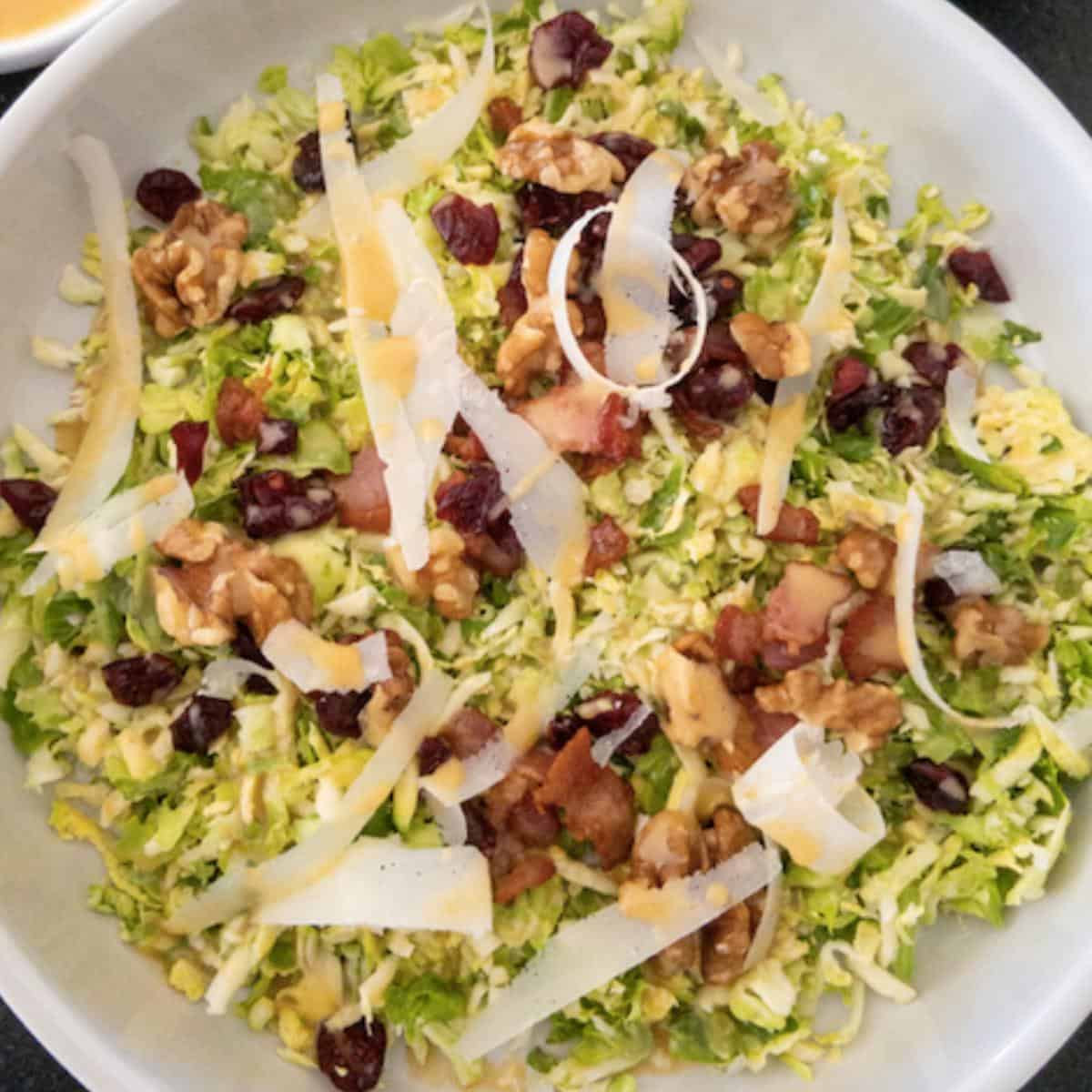 close up of parmesan bacon brussel sprout salad in white bowl