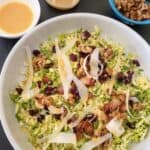 brussel sprout salad in bowl with side of spicy honey mustard and bowl of walnuts
