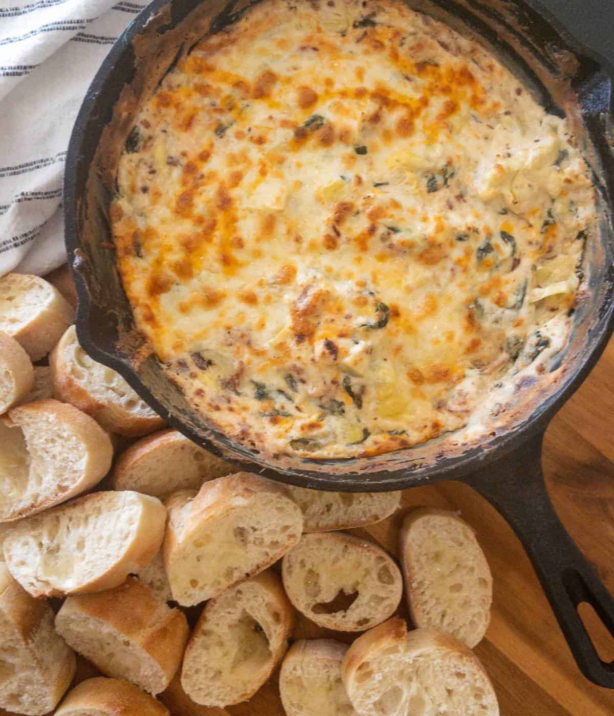 Spinach artichoke dip with no mayo in cast iron skillet.