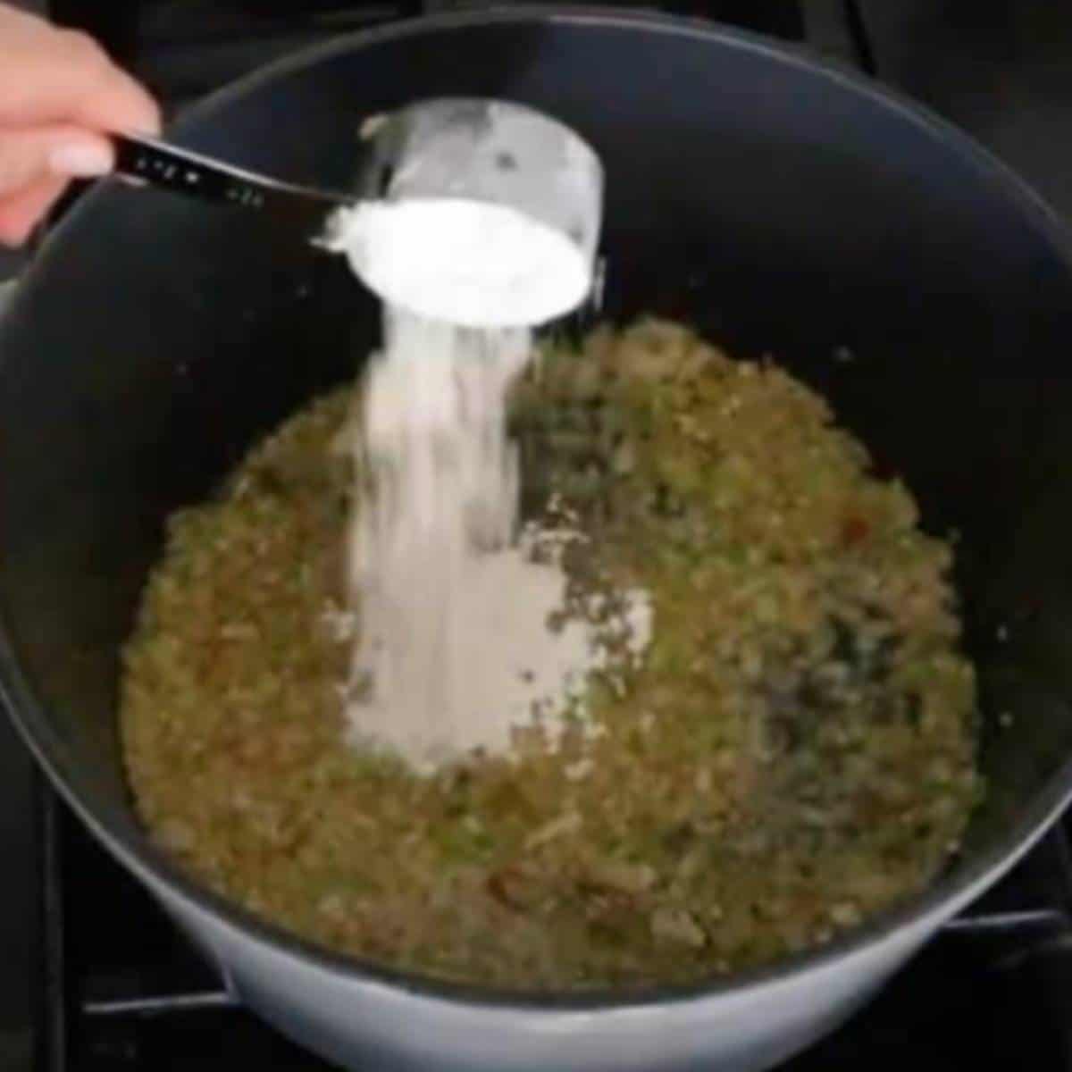 Flour pouring into vegetables.