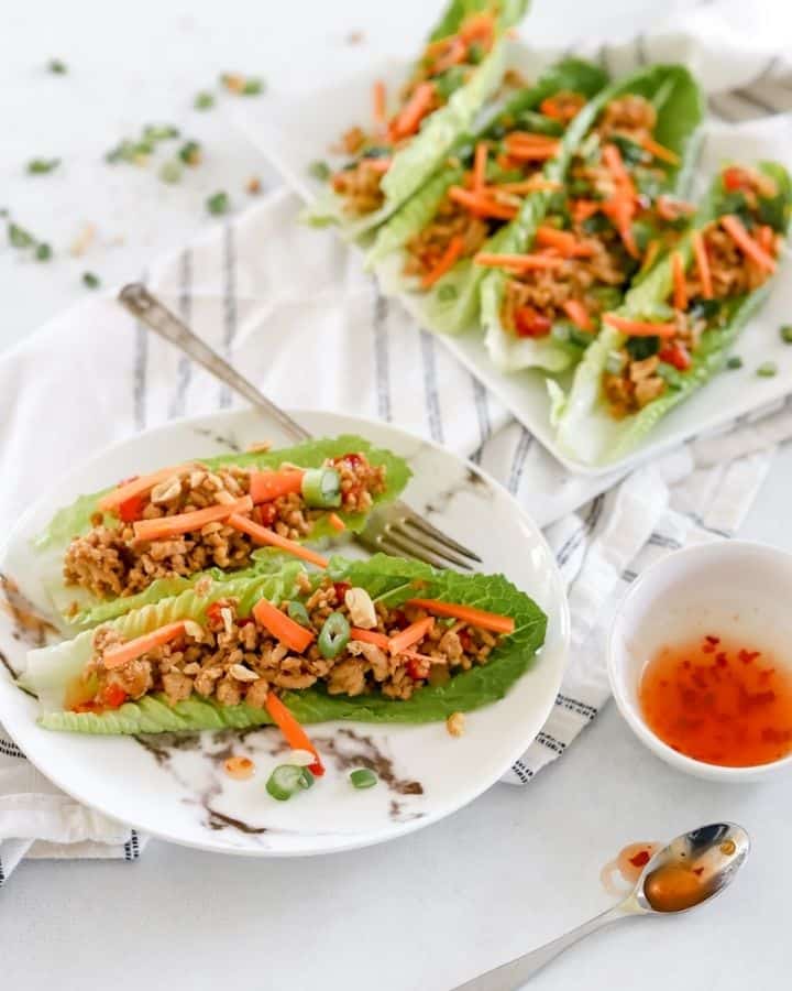 lettuce wraps on a plate with side of red chili dipping sauce