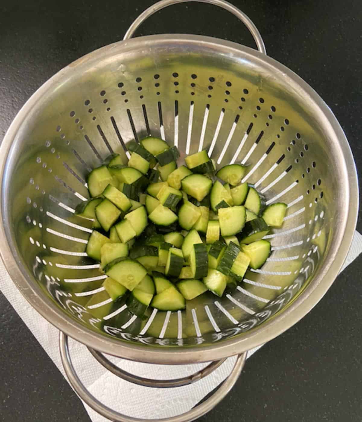 Cucumbers in colander with salt to release moisture.