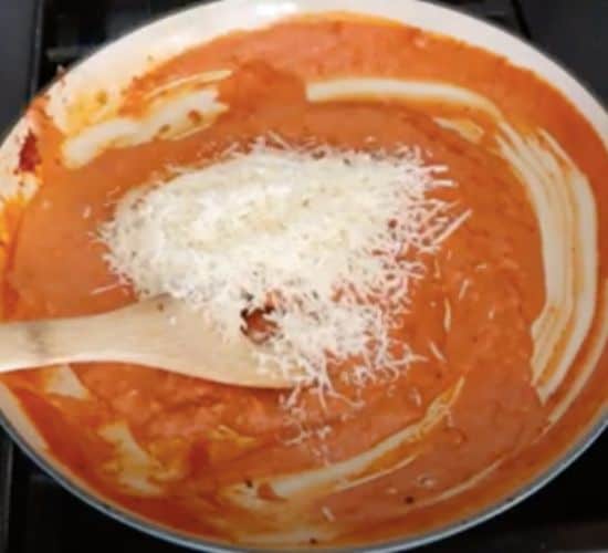 adding cheese to sauce in skillet