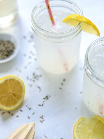 two ball jars filled with lavender lemonade and pink straws
