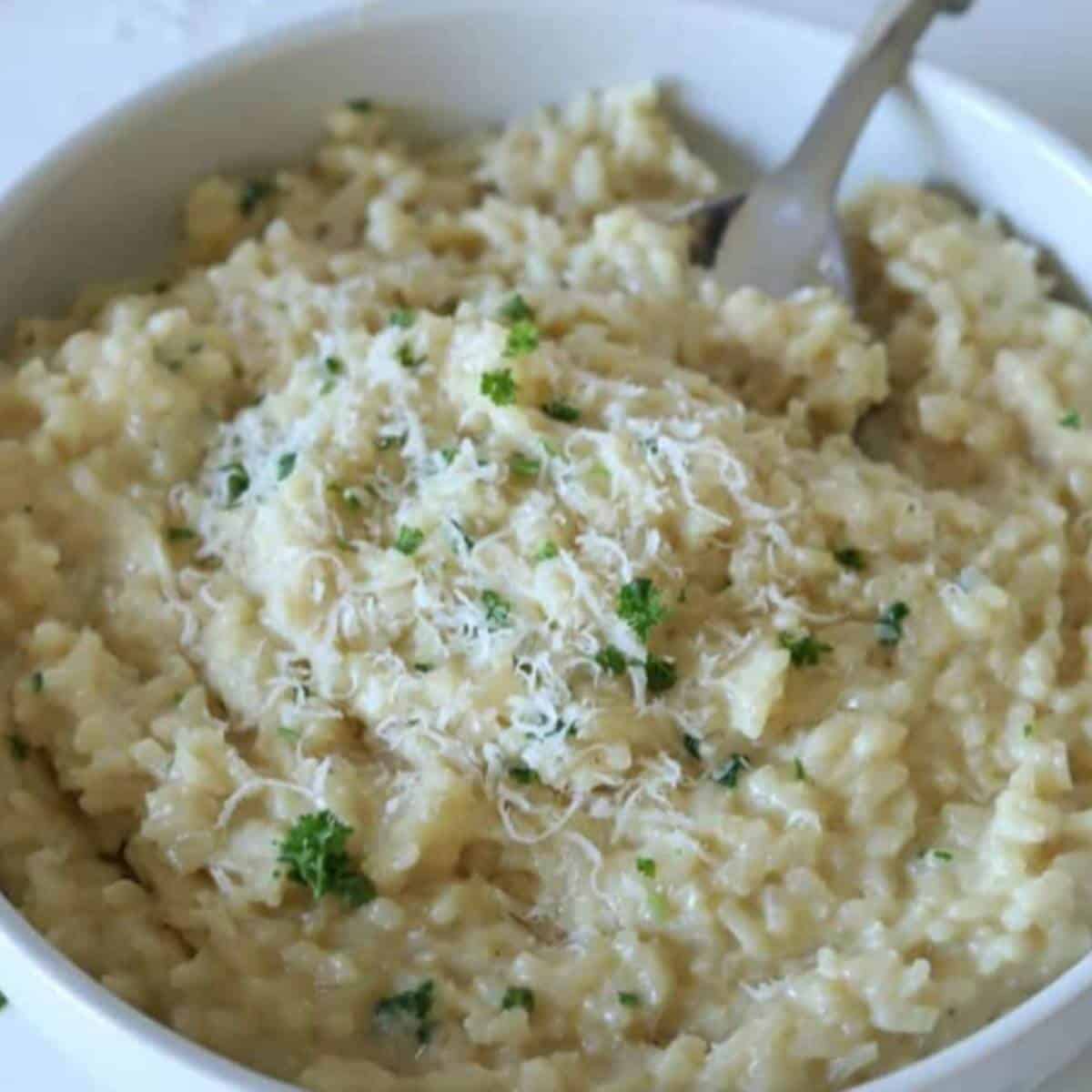 Creamy garlic parmesan risotto topped with parsley in serving dish.