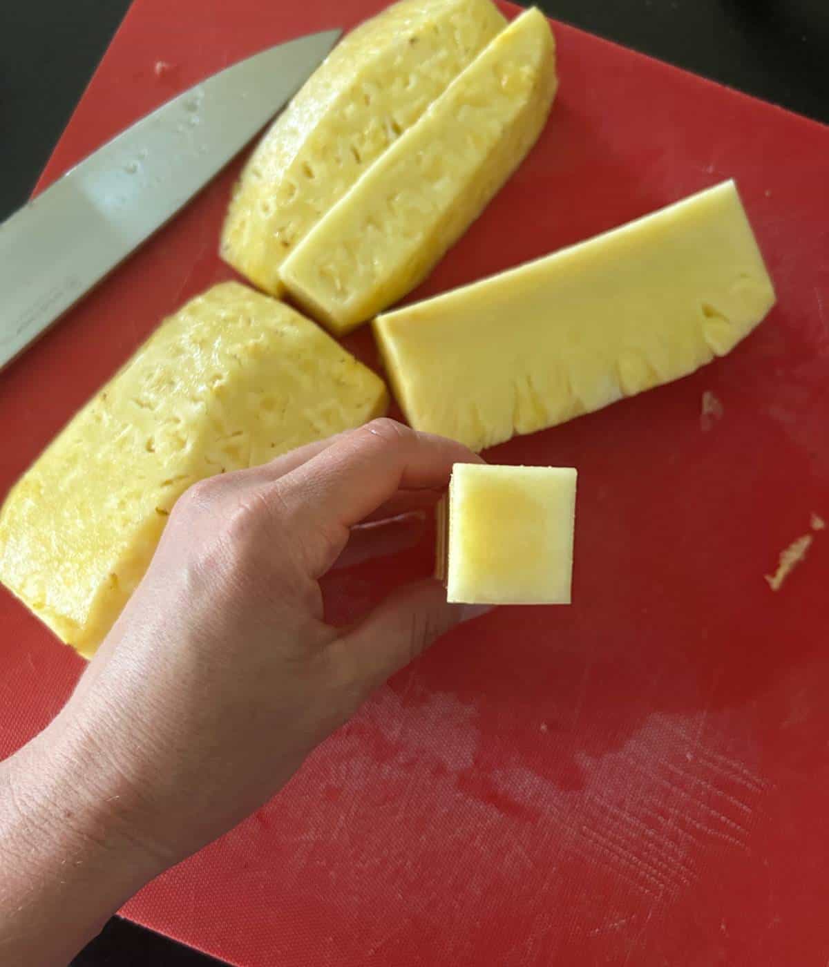 Slicing pineapple into sections and removing the core.