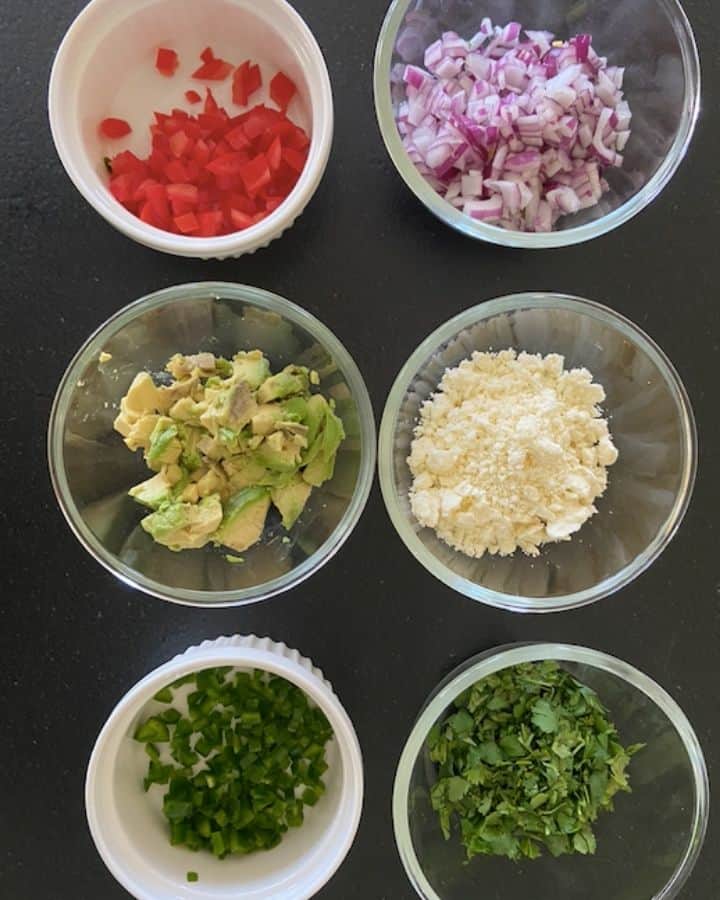 chopped up ingredients for mexican street corn dip with avocado