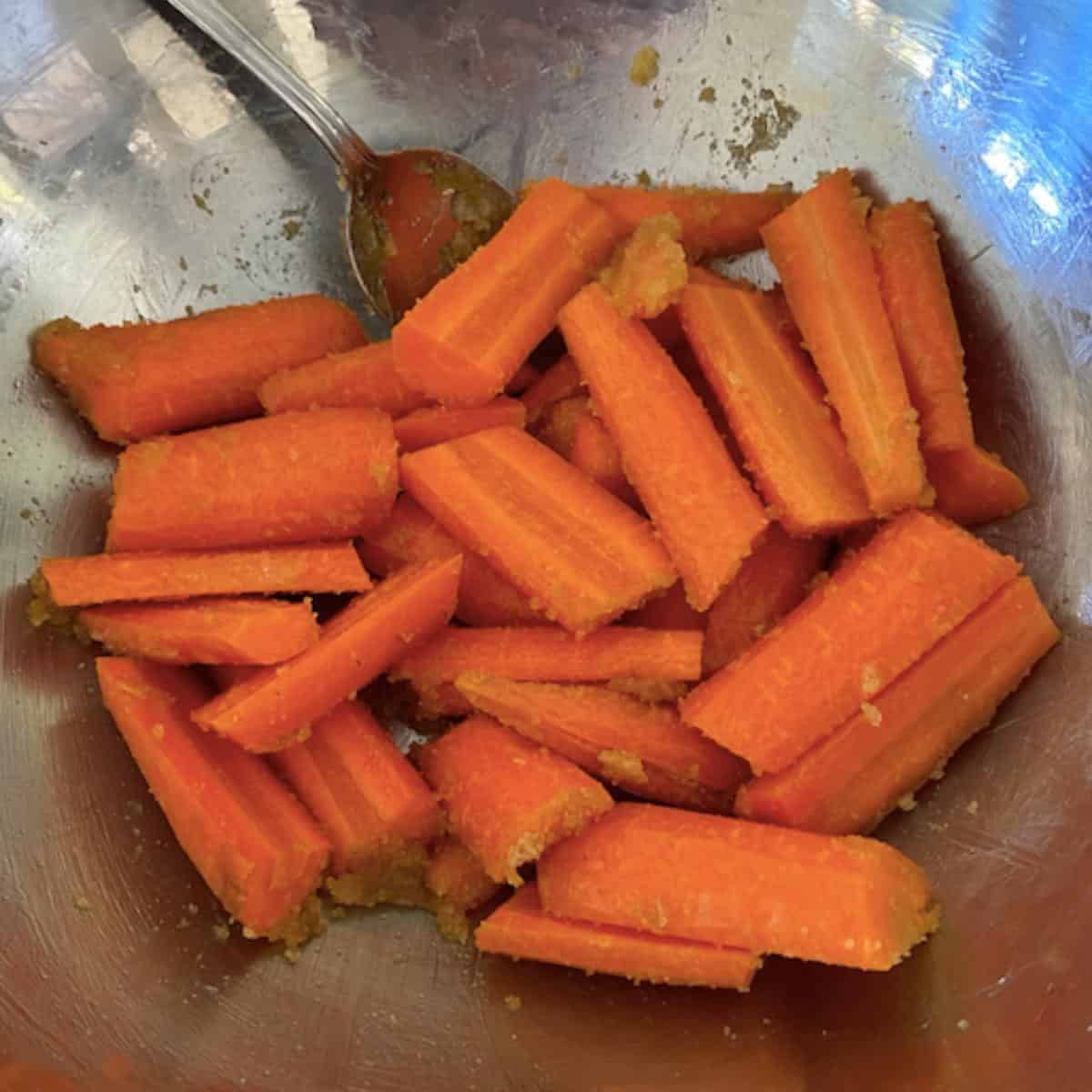 carrots in stainless steel bowl tossed in glaze