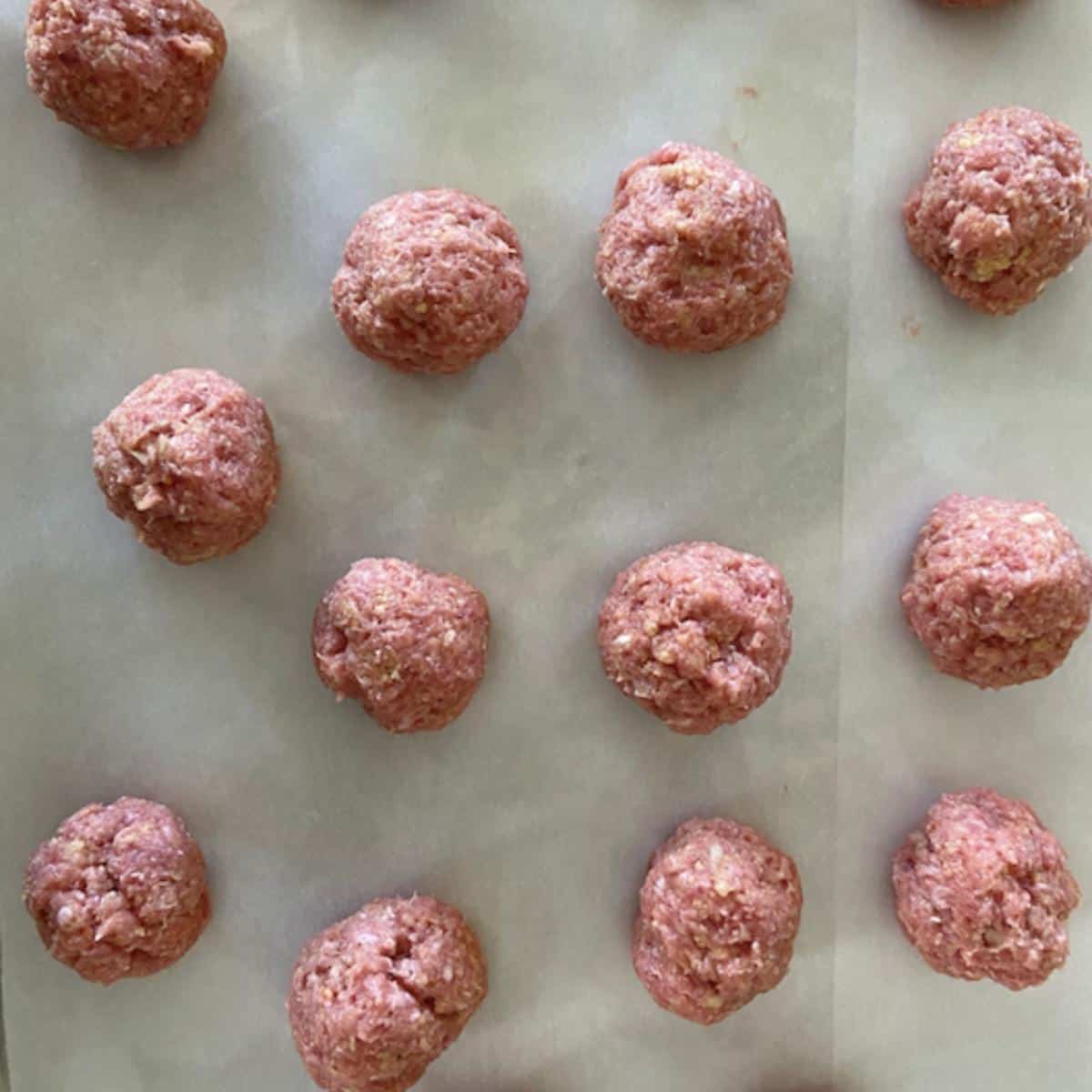 meatballs on parchment paper on cookie sheet