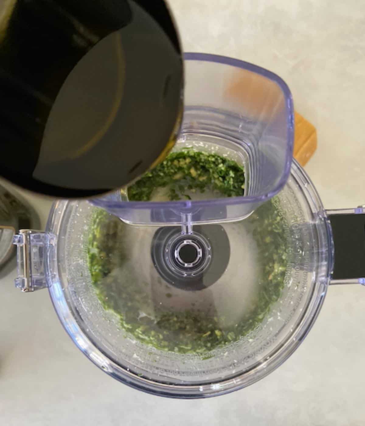 Slowly pouring olive oil into food processor