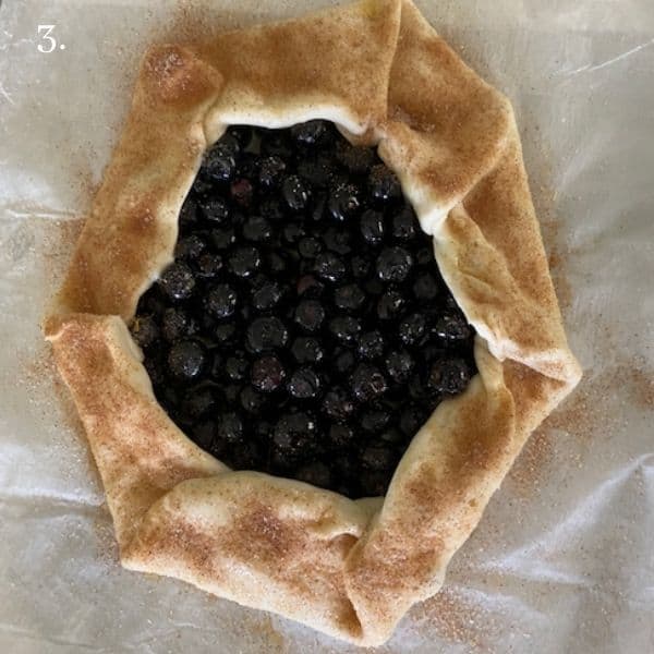 blueberry galette with pastry dough folded into galette shape sprinkled with cinnamon and sugar