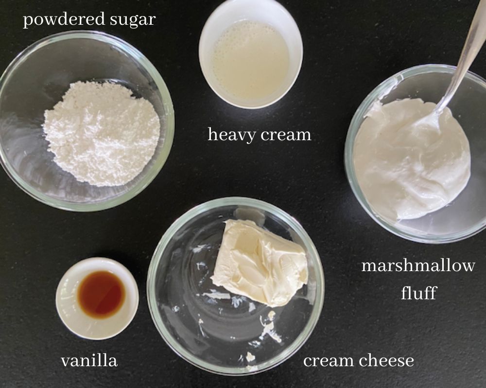 ingredients for marshmallow fluff fruit dip on black counter top with text