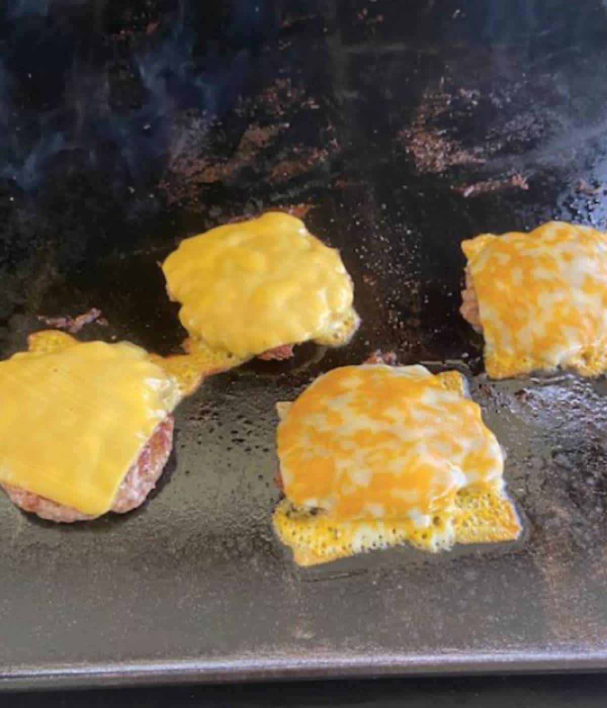Cheese melting on Smashburgers.