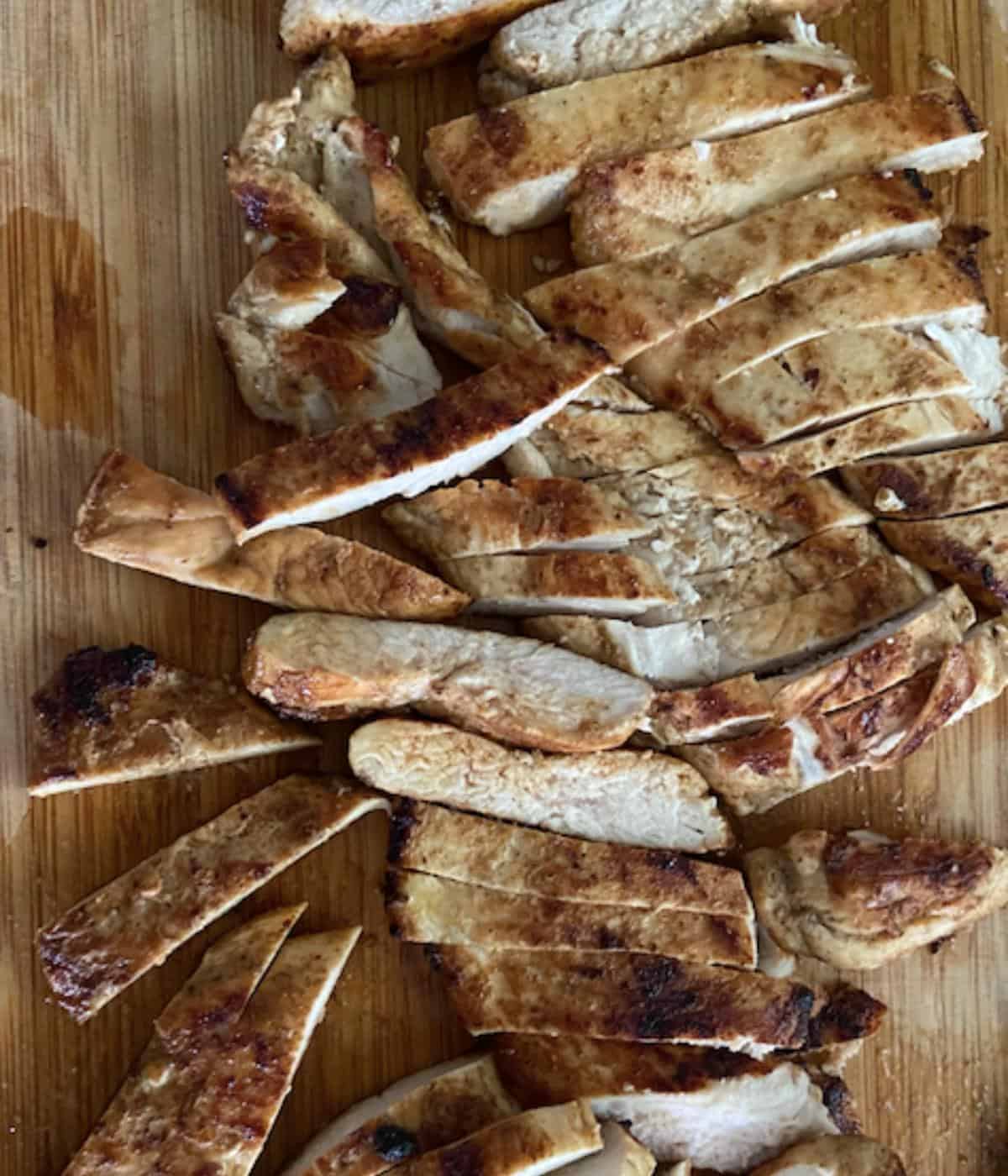 chicken breast sliced into strips on a cutting board