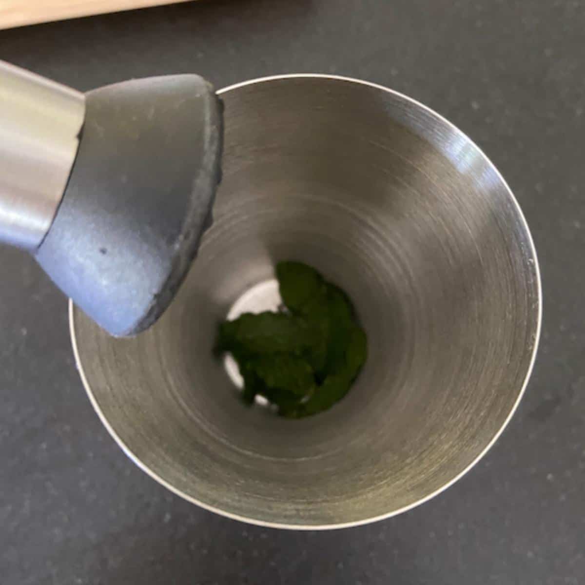 shaker with mint inside about to muddle