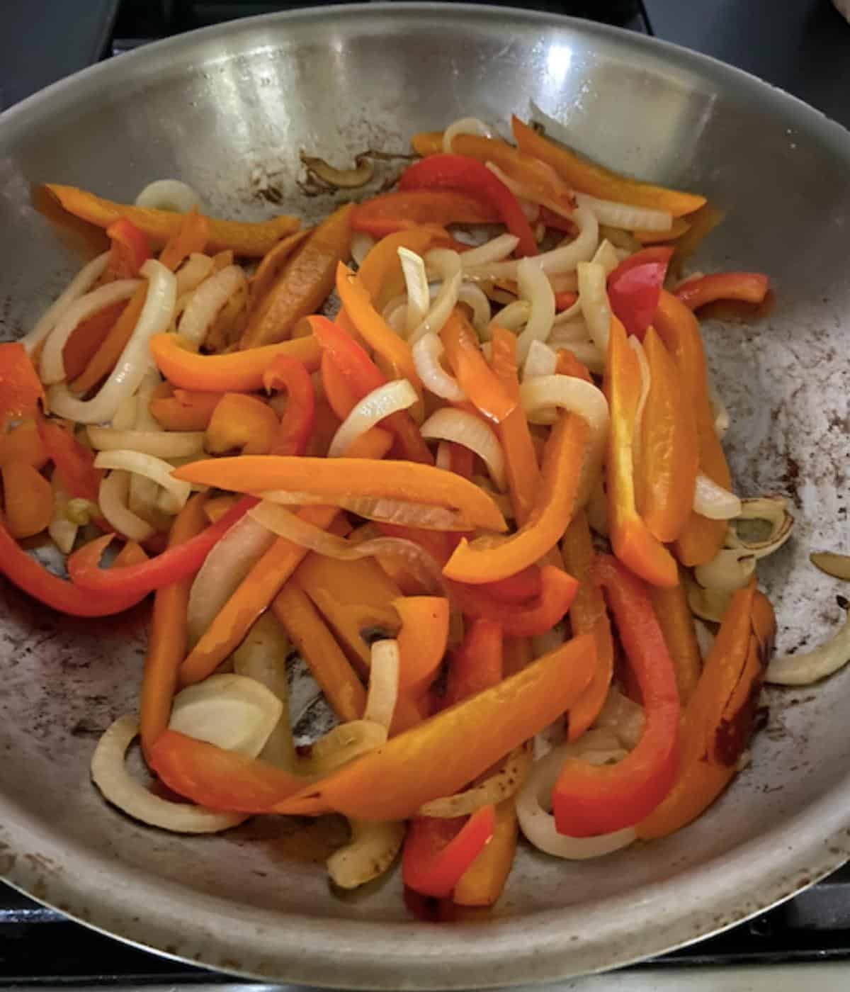 peppers and onions sautéing in pan