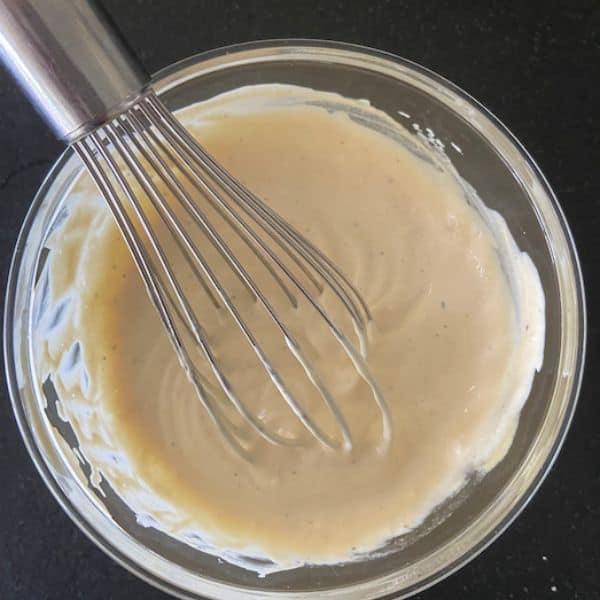 glass bowl with smash burger sauce and whisk