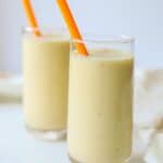 two glasses of banana peach smoothies with orange straws
