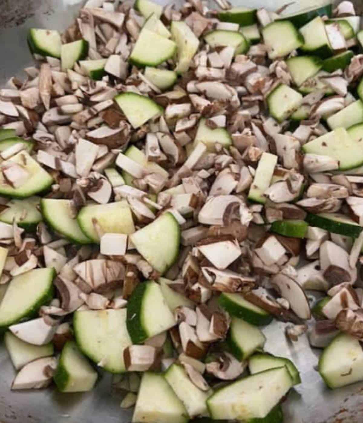 Mushroom and zucchini cooking in pan.