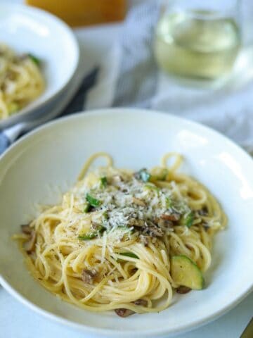 bowl of mushroom zucchini pasta topped with cheese