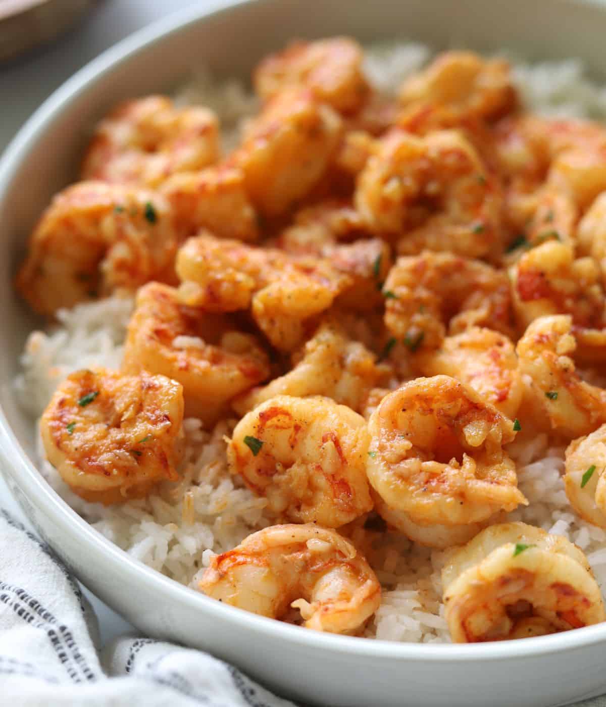 shrimp in a large white bowl over a bed of white rice