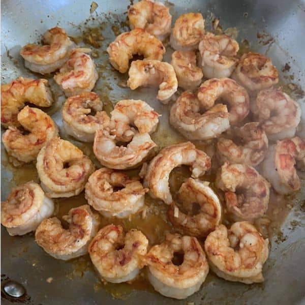 shrimp cooking in pan about to be flipped