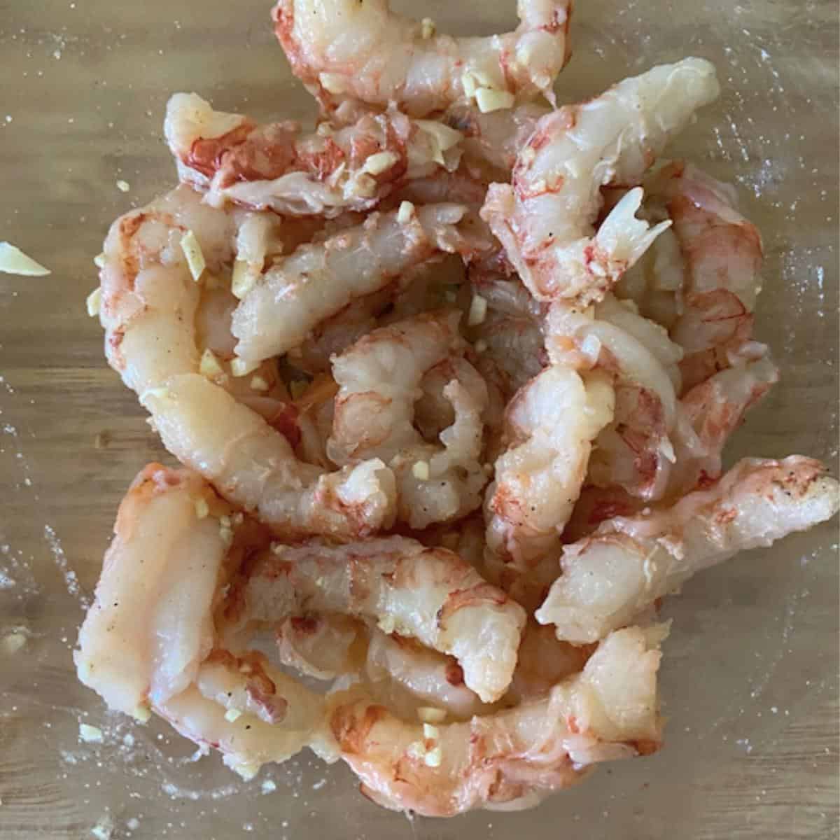 bowl of shrimp mixed with garlic, butter and seasoning