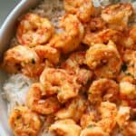 An overhead close up view of the garlic butter shrimp over a bed of white rice