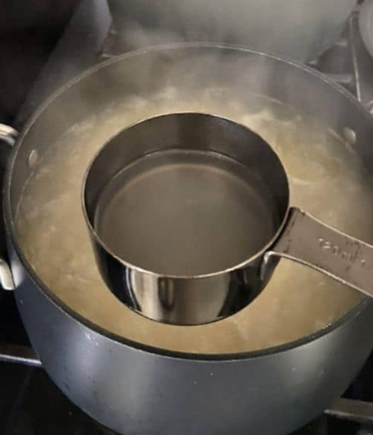 Reserving pasta water from boiling pot.