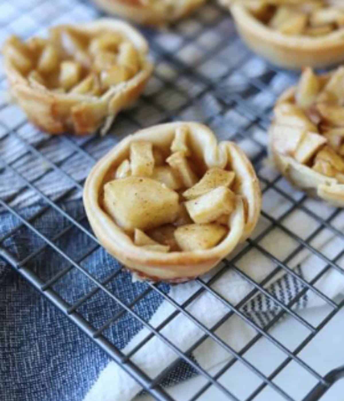 Mini apple pies on baking rack.