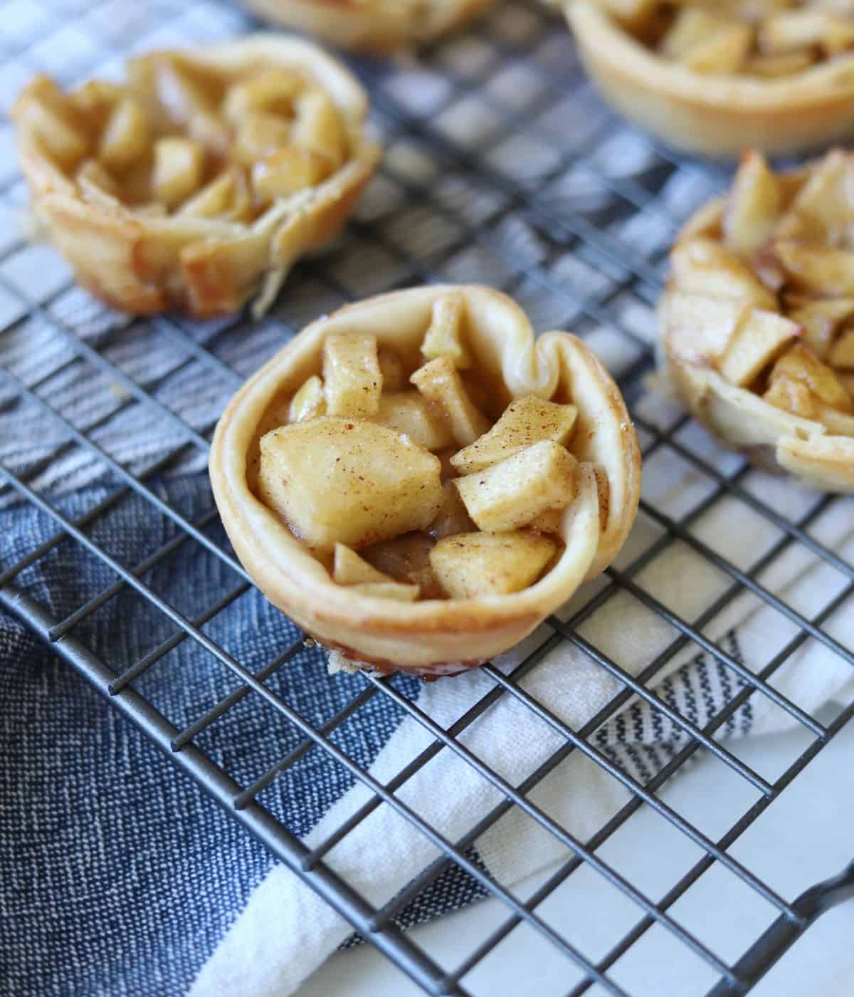 close up of top of mini apple pie on baking rack