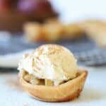 close view to mini apple pie topped with ice cream and cinnamon
