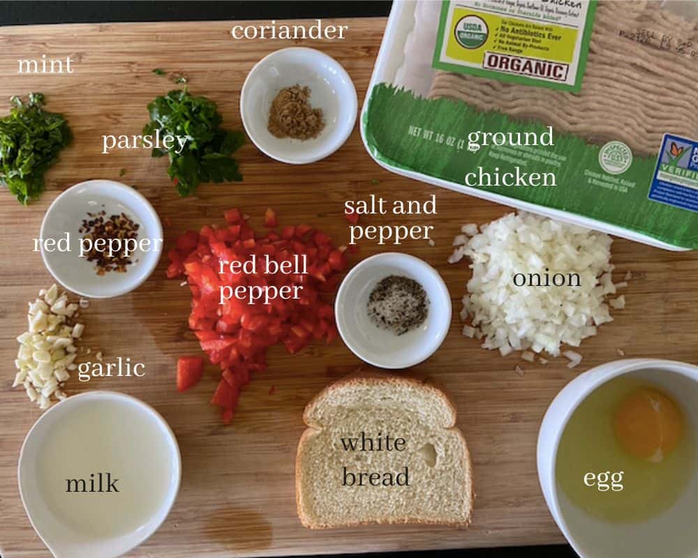 ingredients for chicken kofta on cutting board with text