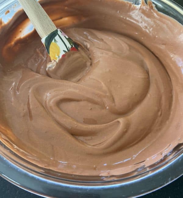 cool whip added to chocolate pudding in bowl