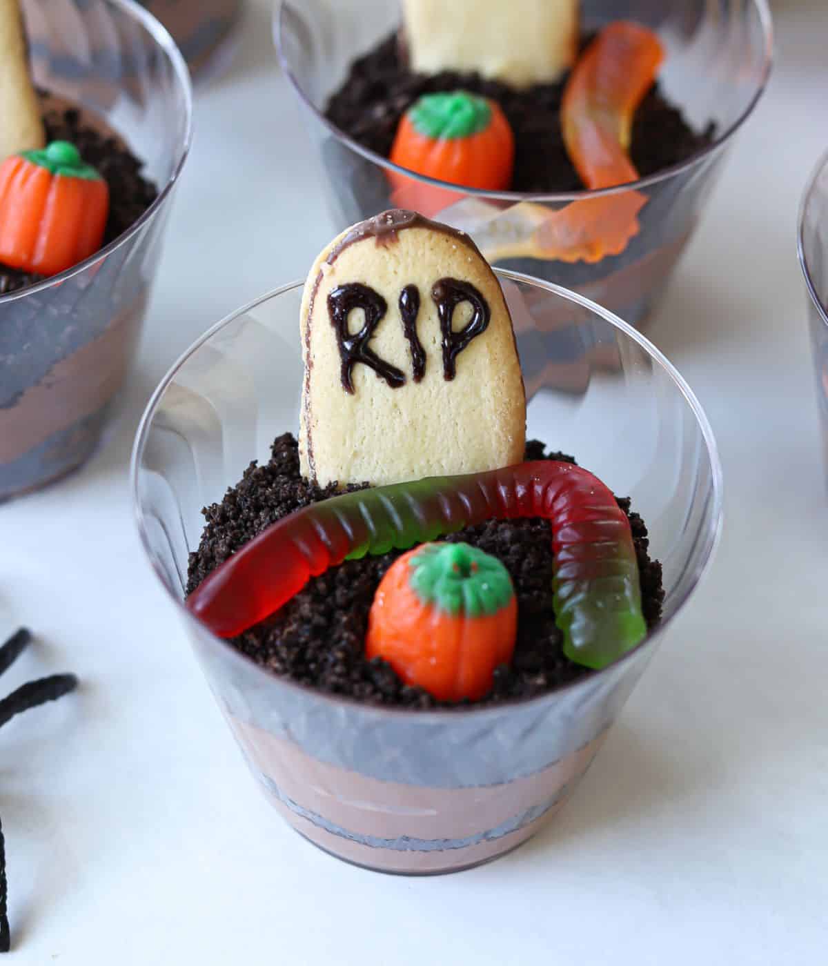 dirt cup topped with RIP cookie, gummy worm and pumpkin