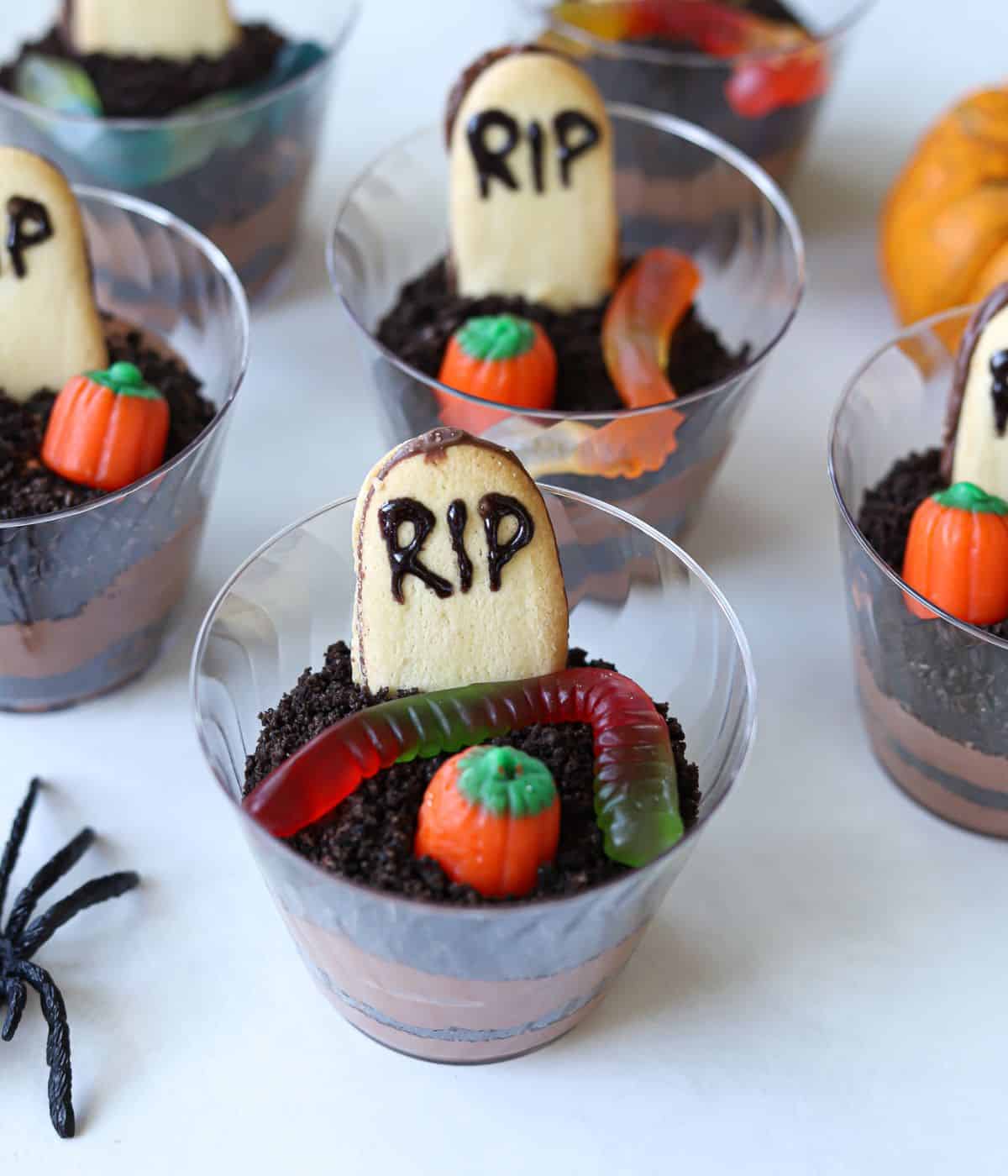 dirt cup topped with RIP cookie, gummy worm and pumpkin