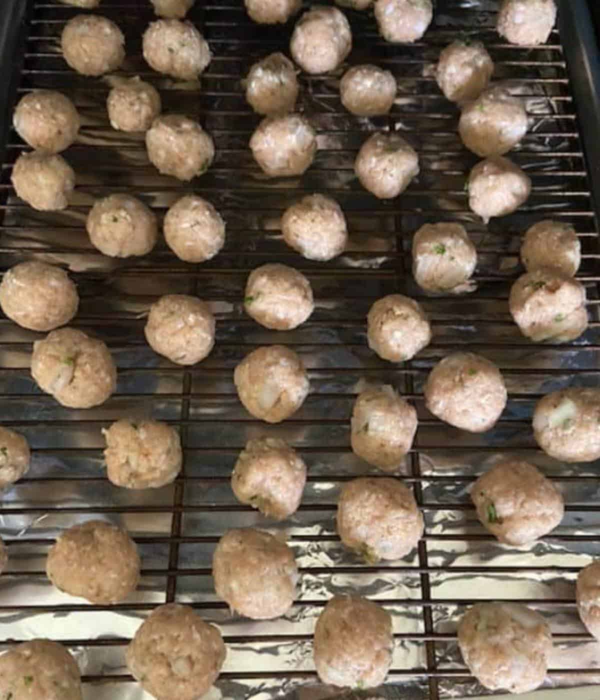Mini meatballs for soup on baking tray.