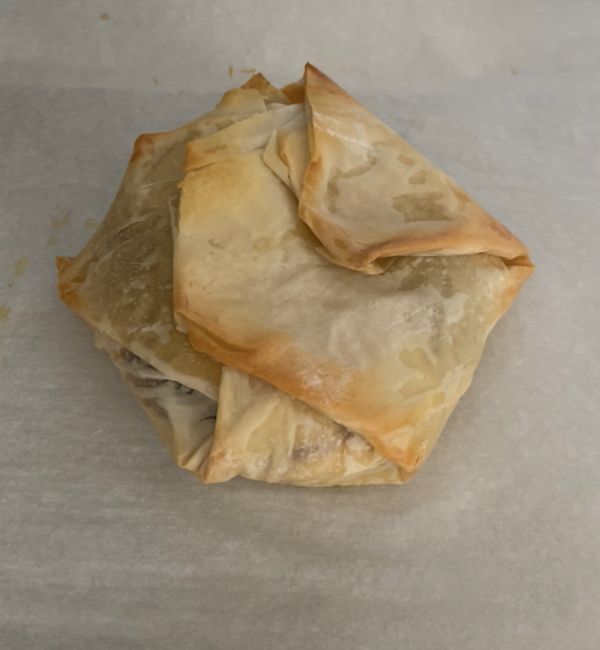 baked brie on parchment paper with golden brown phyllo crust
