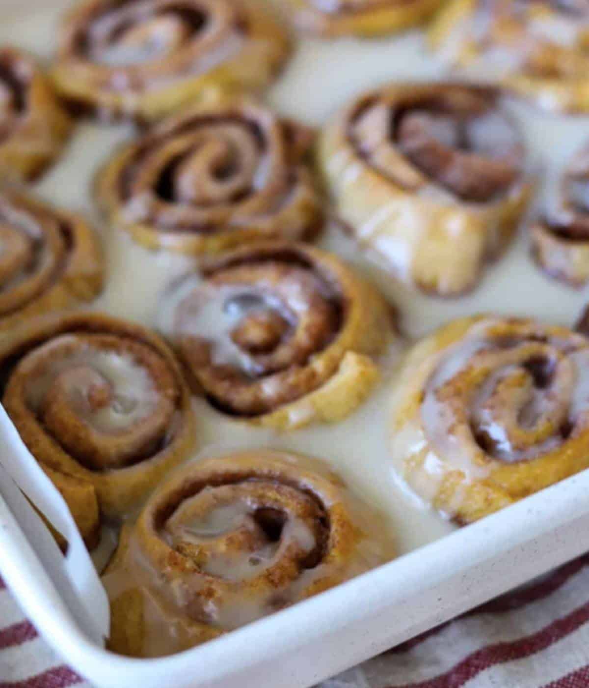 Crescent rolls cinnamon rolls with icing in pan.