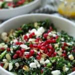 close up of kale salad topped with pomegranate seeds
